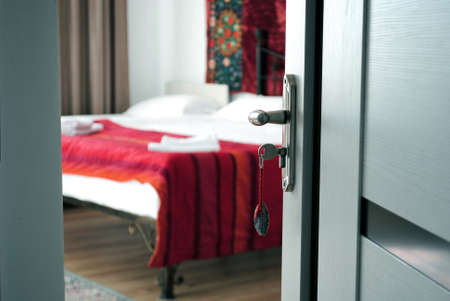 Hotel room interior with a key in the doorの写真素材