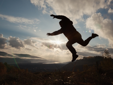 Happy man jumping at the sunset の写真素材
