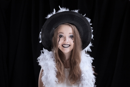 girl in a hat,  halloween face art on black background の写真素材