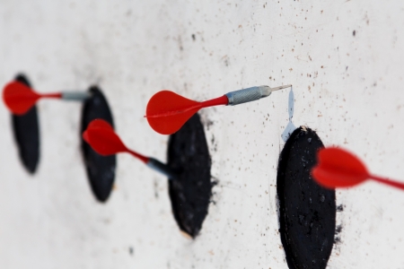 darts arrows in the target center in open airの写真素材