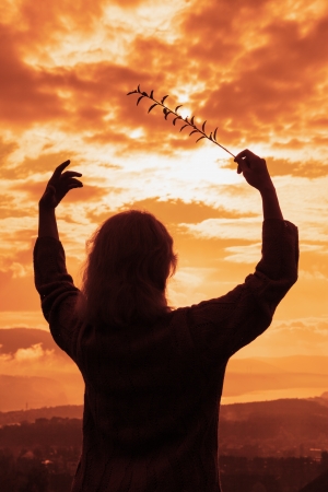 silhouette of the woman conducts a sunsetの写真素材