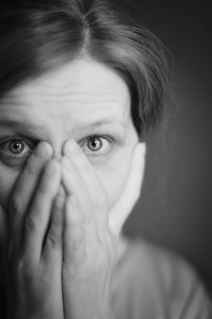 The surprised or scared woman covering her mouth by her hands の写真素材