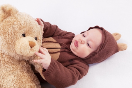 Portrait of the child in a suit of a bear a bear a toyの写真素材