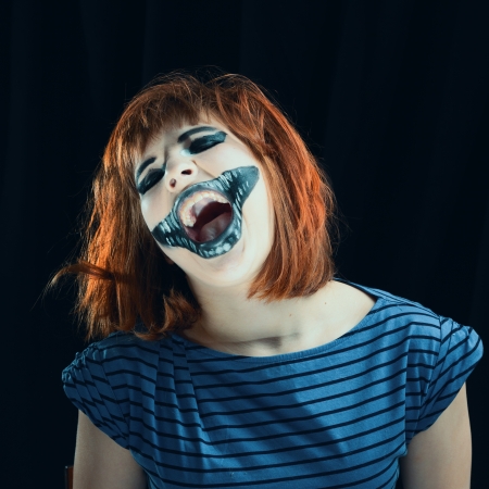 Portrait of the red-haired girl makeup up for celebrating  Halloween, on a black backgroundの写真素材