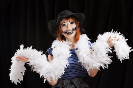 Portrait of the red-haired girl makeup up for celebrating  Halloween, on a black background