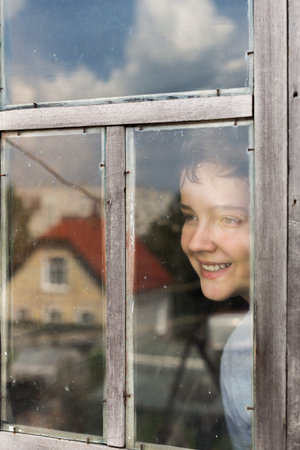 Portrait of an boy peeping through window