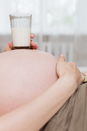 Pregnant woman relaxing at home on the bedの写真素材
