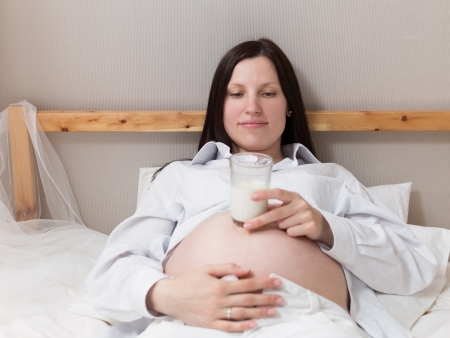 Pregnant woman relaxing at home on the bedの写真素材