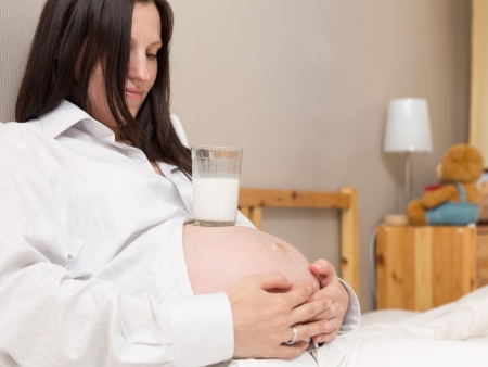 Pregnant woman relaxing at home on the bedの写真素材