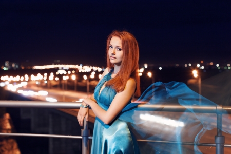 Young beauty woman in fluttering blue dress outdoorの写真素材