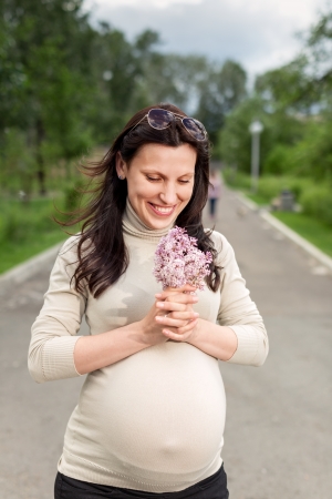 Beautiful pregnant woman relaxing outside in the park の写真素材