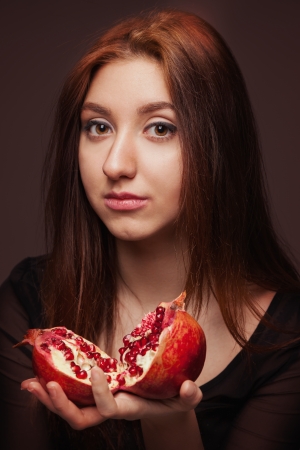 Dark portrait of young girl with pomegranateの写真素材