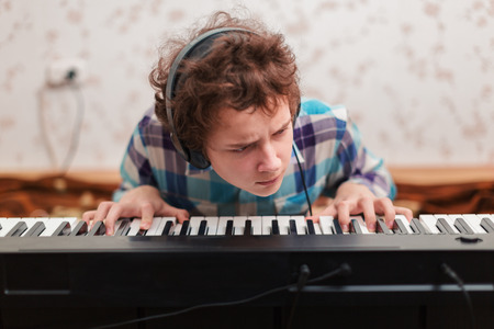 A shot of teenager boy playing piano の写真素材