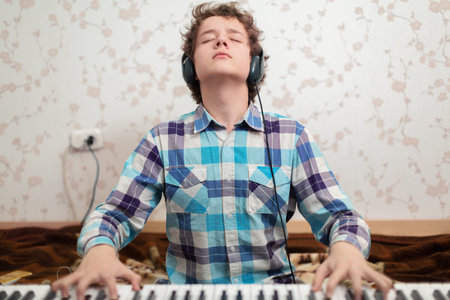 A shot of teenager boy playing piano の写真素材