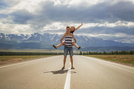 Couple of happy teenagers on the road near Kurai Ridgeの写真素材