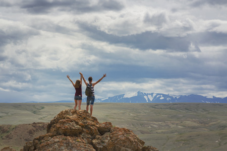 Teen girl and a guy on a mountain topの写真素材