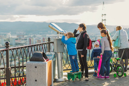 Krasnoyarsk, Russia - September 03 2016: The boy looks through a telescope on the observation platform of Mount Pokrovskayaのeditorial素材