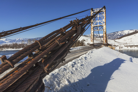 Bridge over the Katun River near the village of Multa in early spring, Altai, Russiaの写真素材