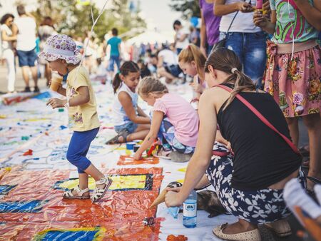 Krasnoyarsk, RUSSIA - August 25, 2018: Girl eats ice cream, woman feeds an ermine with ice cream on a banner on of Mira street for drawing with colorful sticky scotch, 390th of founding Krasnoyarskのeditorial素材