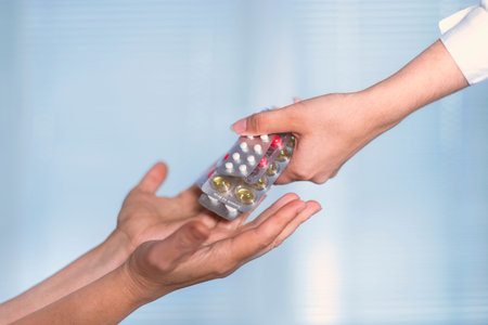 Hands in a white coat serve many pills in a woman