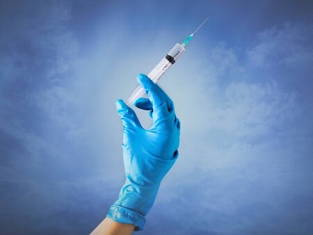 Disposable syringe with a colorless liquid in a  handの写真素材