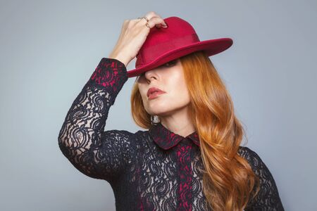 Portrait of a woman in a red hat, studio portraitの写真素材