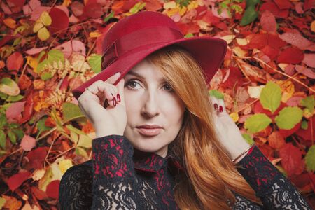 Autumn mood of beauty: portrait of a woman in a red hat, close-up, photo collageの写真素材