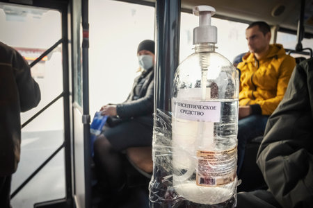 Krasnoyarsk, Russia - April 6, 2020: Antiseptic agent bolted to the handrail of the bus during the...