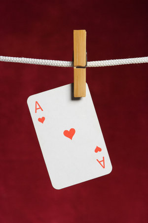 heart ace with clothes peg  rope on red background