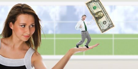 business woman hold man with dollar on palm over windowの写真素材