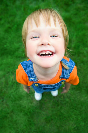 beauty child portrait from above  perspective on green grass