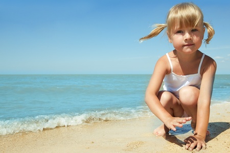 little girl child on the sea under blue skyの写真素材