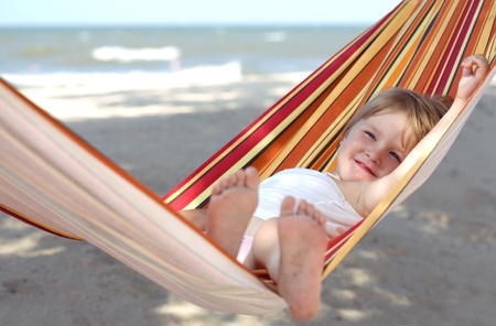 child relaxing in a hammock on the sea beachの写真素材