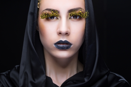 Portrait of a woman with bright makeup on black backgroundの写真素材