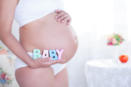 beauty pregnant woman in white interiorの写真素材