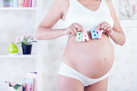 beauty pregnant woman in white interiorの写真素材