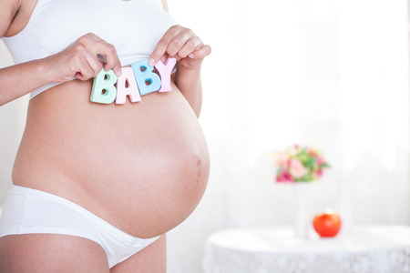 beauty pregnant woman in white interiorの写真素材