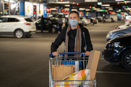 Woman wearing a mask on her face to protect herself from covid virus in a shopping mall parking lot...