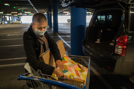 Woman wearing a mask on her face to protect herself from covid virus in a shopping mall parking lot...