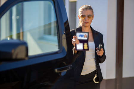 Special federal intelligence agent woman in black suit and big police carの写真素材