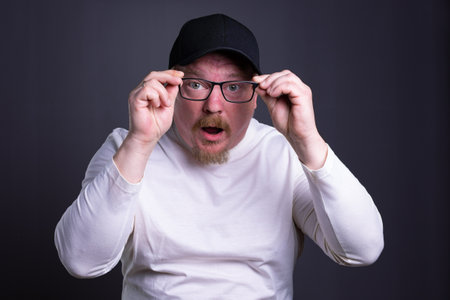 Portrait of an emotional man with glasses on a gray background surprise I remembered something forgotの写真素材