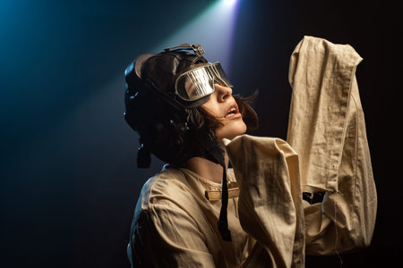 Mad Woman In A Straitjacket And A Pilot Helmet With Glasses Goes Crazy In The Rays Of Light And...
