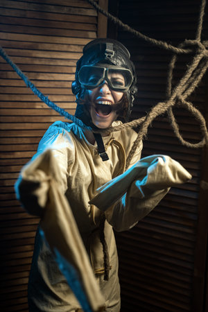 Mad Woman In A Straitjacket And A Pilot Helmet With Glasses Goes Crazy In The Rays Of Light And...