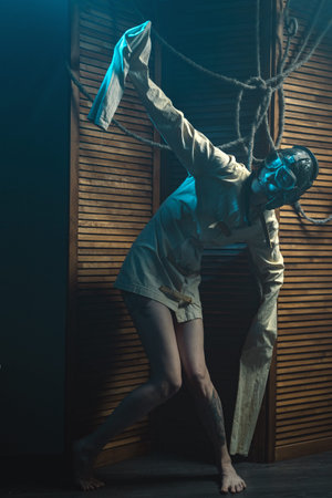Mad Woman In A Straitjacket And A Pilot Helmet With Glasses Goes Crazy In The Rays Of Light And...