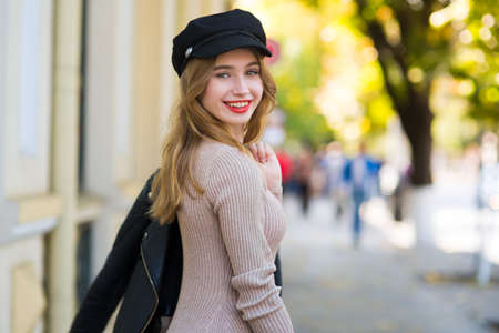 Young beautiful woman walks through city streets between buildingの写真素材