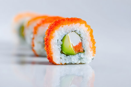 Colorful sushi rolls with fresh tuna and cucumber are artistically arranged on a smooth surface. Perfect for a meal or snack, these rolls showcase vibrant flavors and textures.の素材