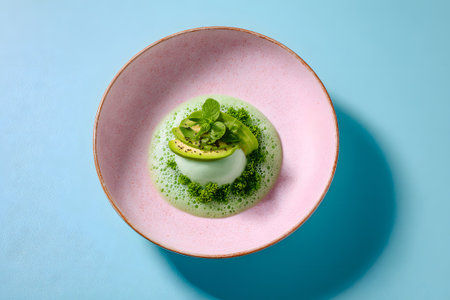 A beautiful green dessert sits attractively in a round dish. It features layers of vibrant ingredients topped with fresh herbs, creating a stunning presentation that highlights culinary artistry.の素材