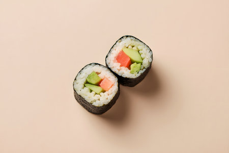 Three sushi rolls sit neatly on a simple background. Each roll contains fresh salmon and creamy avocado, showing vibrant colors. Perfect for sushi lovers.の素材