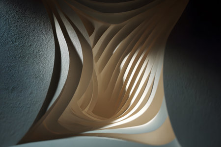 Intricate paper sculpture illuminated from within highlighting curves and shadows in an artistic displayの素材