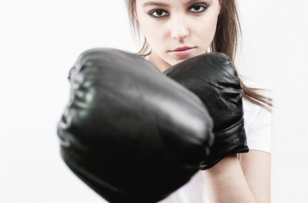 Pretty young woman wearing boxing gloves and looking at camera.の写真素材
